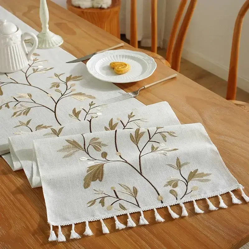 Embroidered cotton linen table runner with tassel details for dining table décor